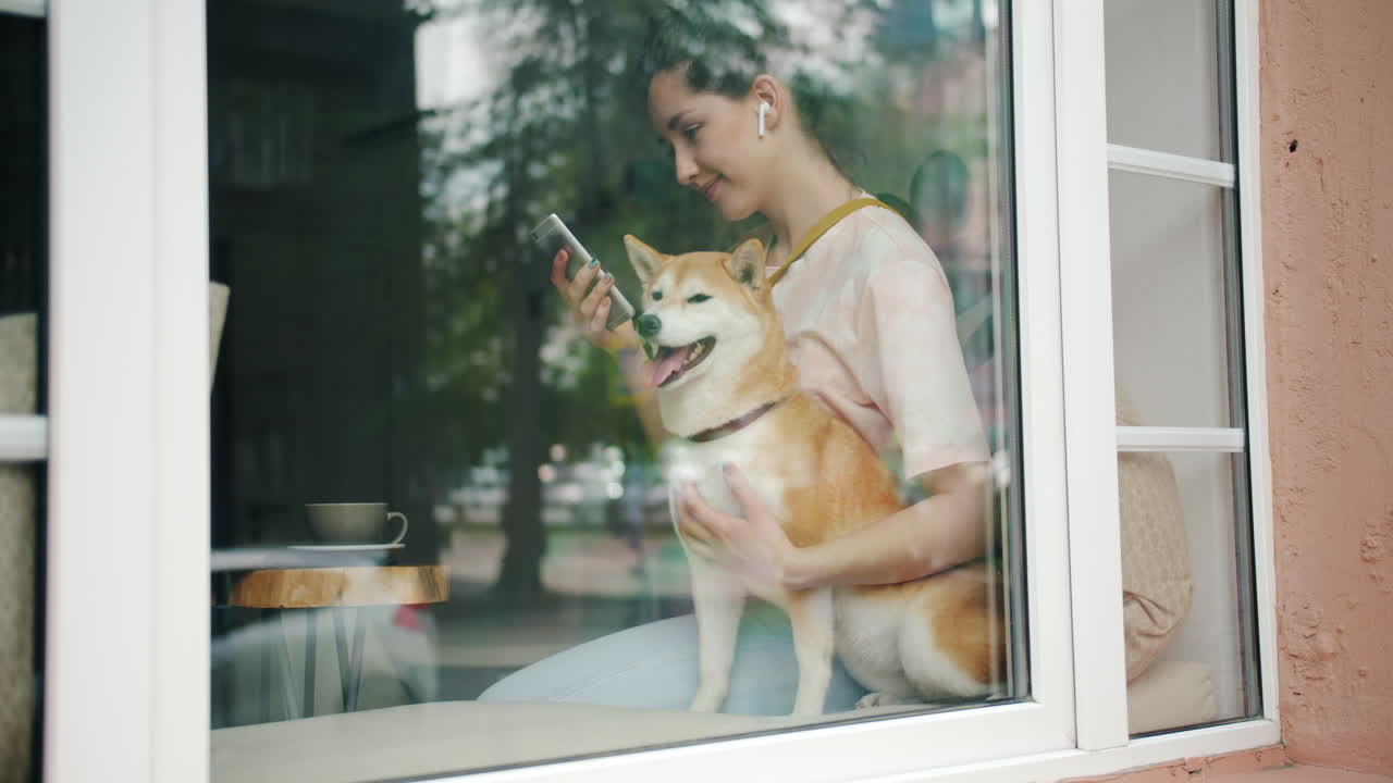 Woman with Shiba Inu at a cafe window