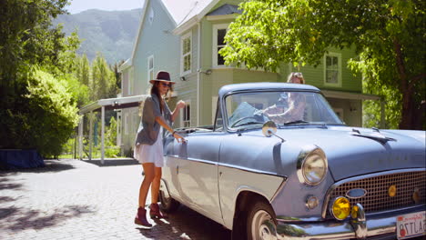 freunde genießen eine fahrt in einem vintage-cabriolet