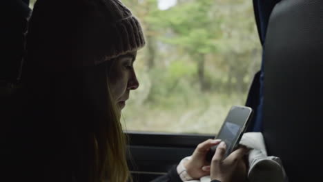 woman in bus uses her mobile phone