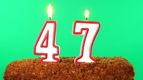 cake with the number 47 lighted candle. chroma key. green screen. isolated