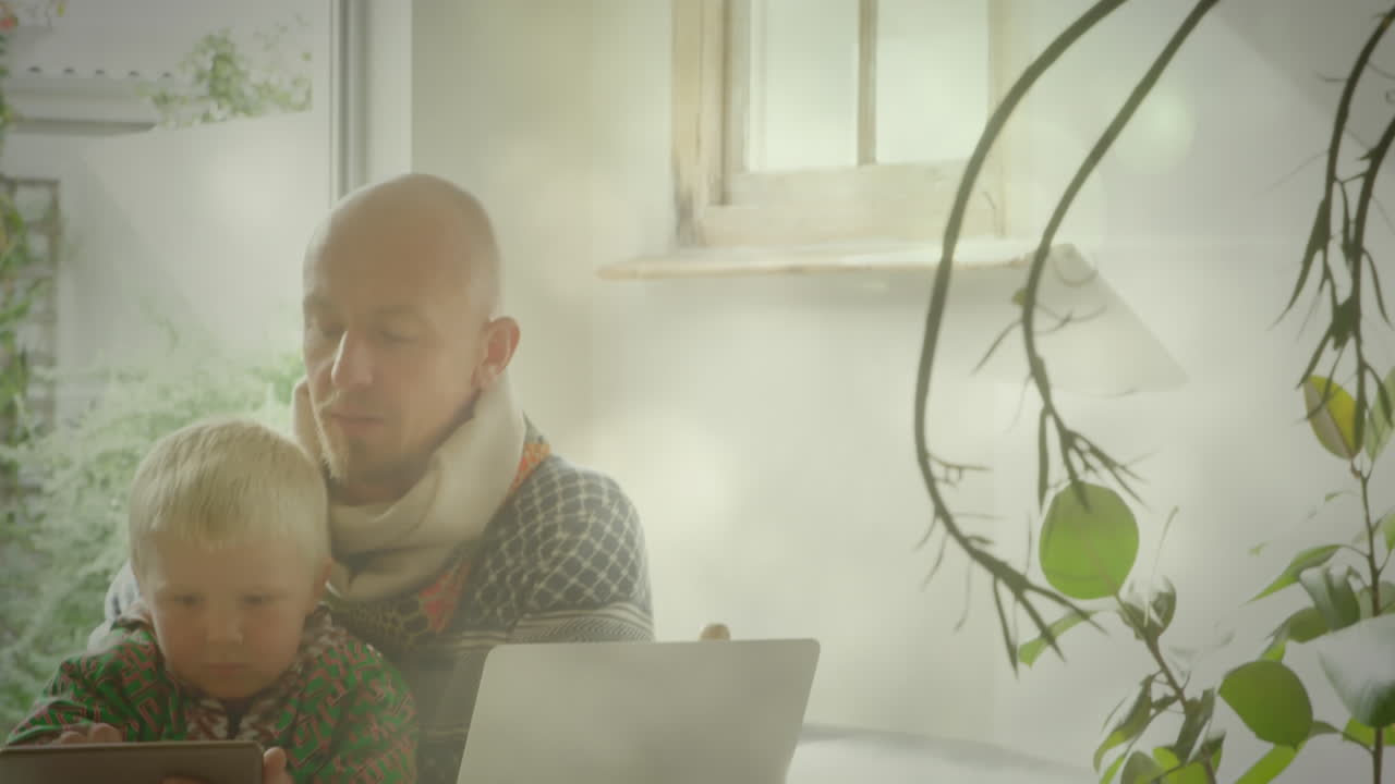 animación de puntos de luz sobre un padre caucásico feliz usando una tableta con su hijo