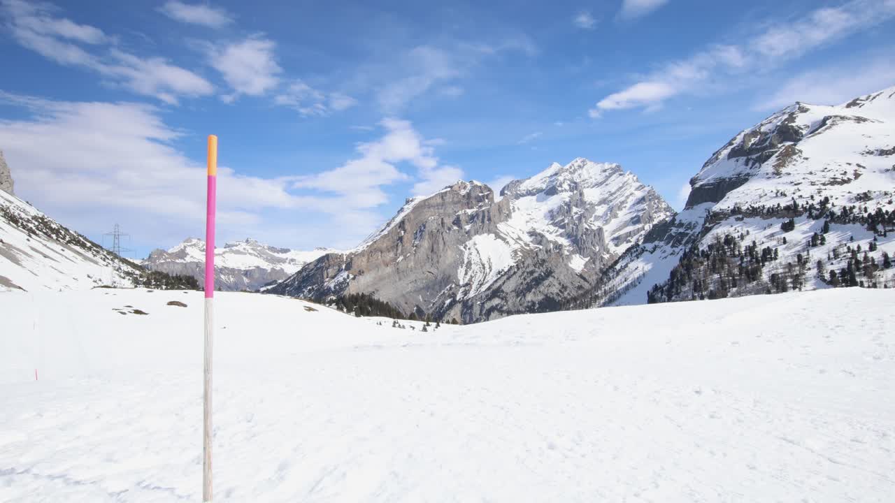 Snow depth marker on winter mountain landscape, wide establisher