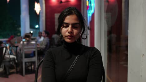sexy mujer del sur de asia en contemplación en un café, por la noche