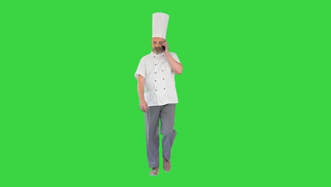chef caminando y hablando por teléfono en una pantalla verde, clave de croma