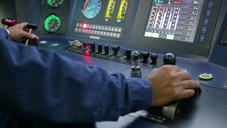 train operator in blue uniform managing controls in locomotive cabin, dials and digital screens visible