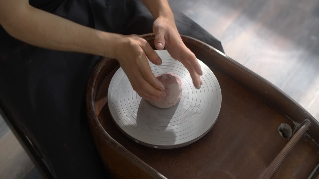 도자기는 네리코미 스타일의 도자기를 조각하기 위해 도자기의 바에 다채로운 점토를 넣습니다. neriage 도자기, 도자기는 느린 동작으로 도자기를 만니다.