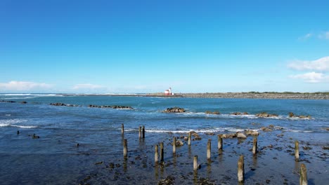 Gorgeous-4K-aerial-drone-shot-hovering-over-shore-towards-Coquille-River-lighthouse-and-ocean-horizon