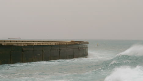 océano agitado con olas aplastando el rompeolas