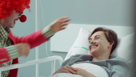 payaso entreteniendo a una paciente en la sala del hospital