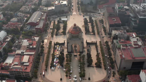 Luftaufnahme-Von-Der-Drohne-Auf-Dem-Berühmten-Revolutionsdenkmal-Auf-Der-Plaza-De-La-Republica.-Kamerawinkel-Kippt-Bis-Zum-Stadtpanorama-Gegen-Sonne.-Mexiko-Stadt,-Mexiko.