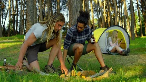 amigos encendiendo una fogata en el bosque 4k