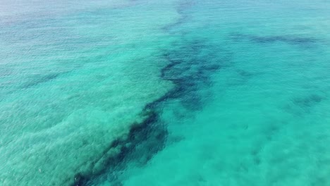 drone flight over crystal clear turquoise water with a view to the reef underwater, in cape verde