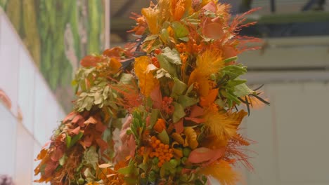 hermosa corona de flores artificiales en colores naranja de otoño