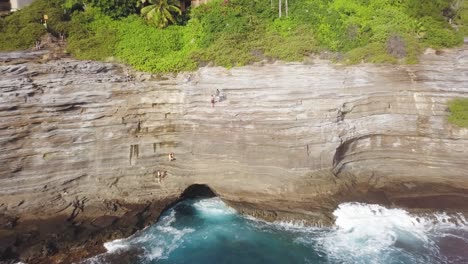 personas de pie en el borde del acantilado de la cueva de escupir en honolulu hawaii - dolly aéreo hacia atrás