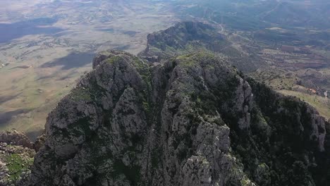 Un-Dron-De-Inclinación-Lenta-Hacia-Arriba-Del-Pico-Y-El-Valle-De-Zaghouan-En-Túnez-Durante-Un-Día-Caluroso-Y-Soleado