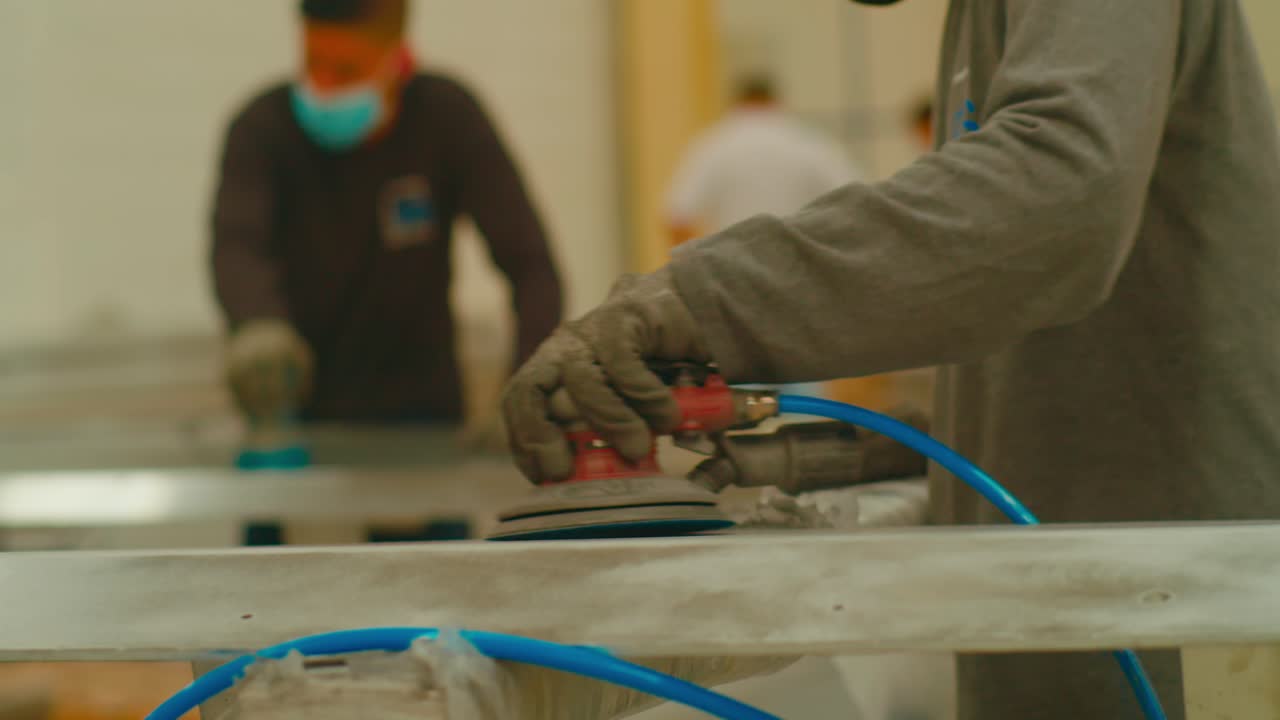 operadores de una fábrica de procesamiento de metales que pulen piezas metálicas