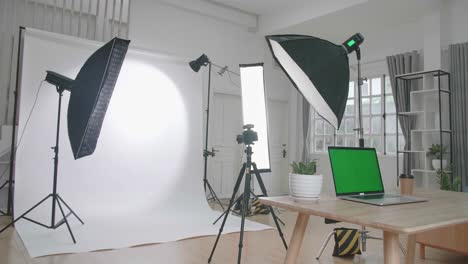 photo studio with professional equipment and green screen laptop computer display