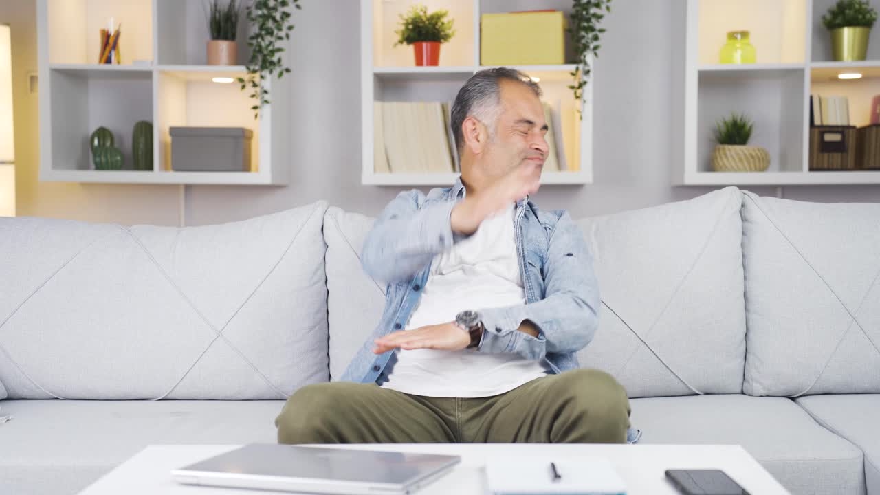 Man closing laptop with angry expression.