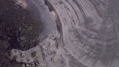 Volcanic-lines-on-coast-of-Stórhöfði-peninsula-of-remote-island-Heimaey,-aerial