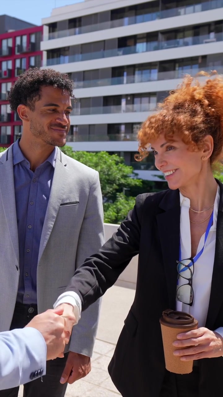 Professionisti d'affari sorridenti che si stringono la mano a un incontro di lavoro all'aperto in città