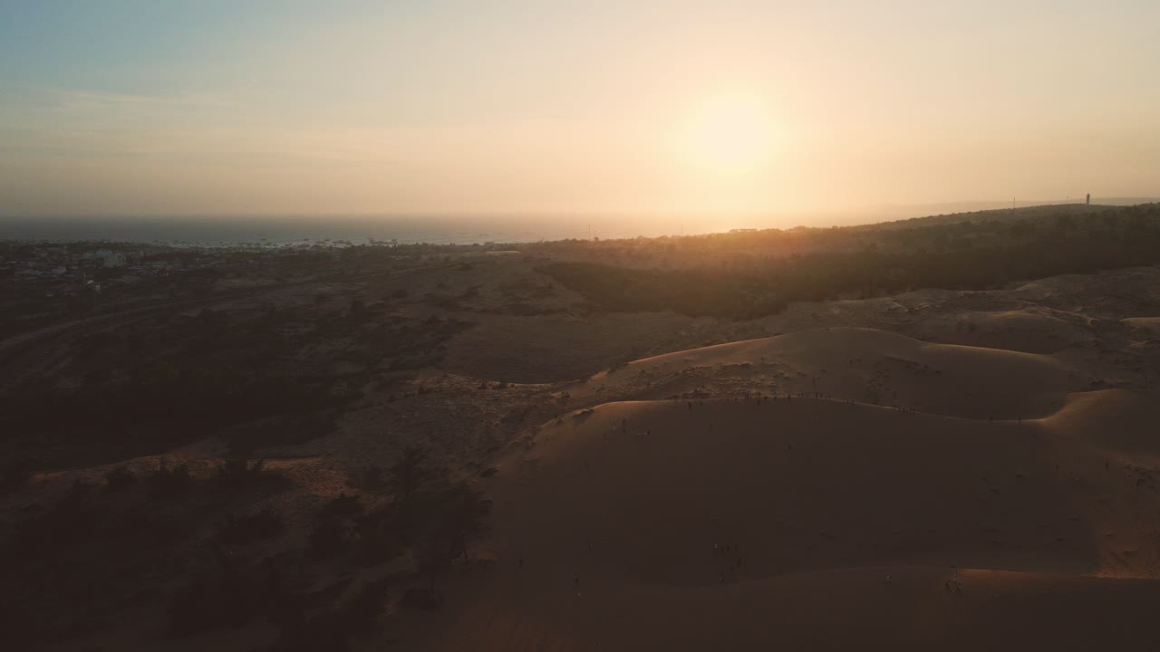 panorama aéreo panorámico sobre dunas rojas de mui ne al atardecer, turistas explorando