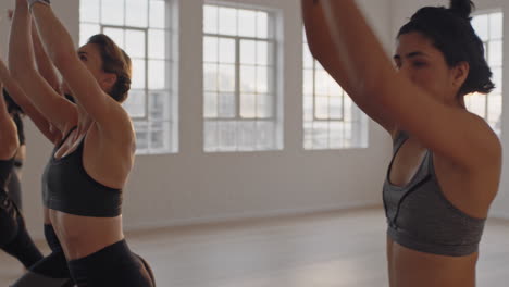 yoga-class-group-of-multiracial-women-practicing-warrior-pose-enjoying-healthy-lifestyle-exercising-in-fitness-studio-instructor-teaching-group-meditation-at-sunrise