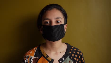 a beautiful south asian indian girl wearing mask in the indoor setting during corona virus pandemic
