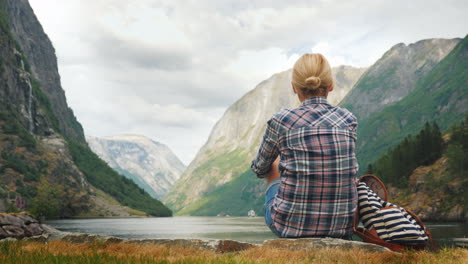 tourist with backpack and flag of norway admires grandiose fjord tourism in scandinavia concept 4k v