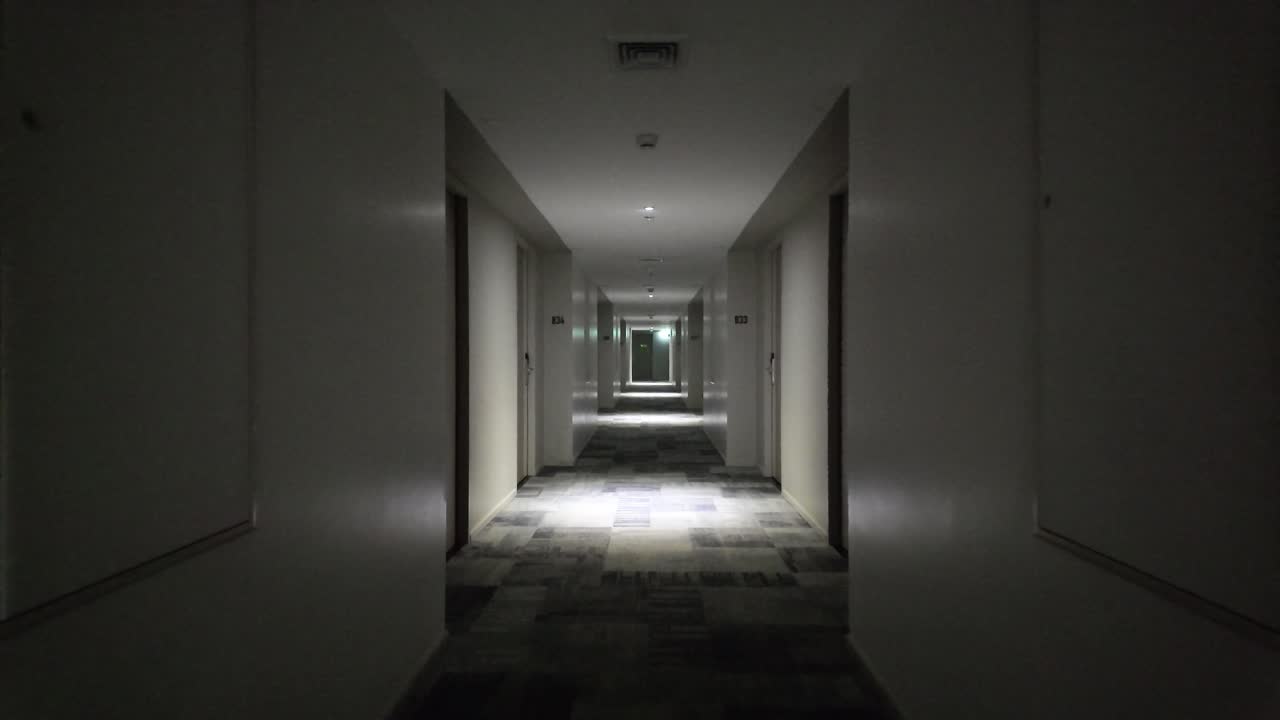 Hotel corridor at night showing a long empty hallway with dim lighting