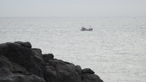 Barco-Pesquero-Que-Sale-De-La-Costa-Rocosa-Para-Un-Viaje-De-Pesca,-Vista-Estática