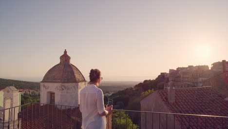 Mujer-Feliz-Usando-Un-Teléfono-Inteligente-Tomando-Fotos-De-Una-Hermosa-Puesta-De-Sol-Disfrutando-Compartiendo-Experiencias-De-Viajes-De-Vacaciones-De-Verano-En-El-Balcón