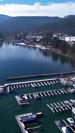 Vertical-Aerial-View,-Tahoe-City-Marina-and-Waterfront-Buildings-on-Lake-Tahoe-on-Sunny-WInter-Day