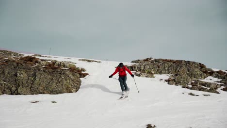 freeskier jumps down the rocky slope during winter season