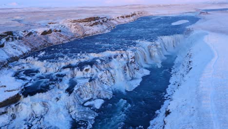 aerial view of frozen gullfoss waterfall in iceland with wild river