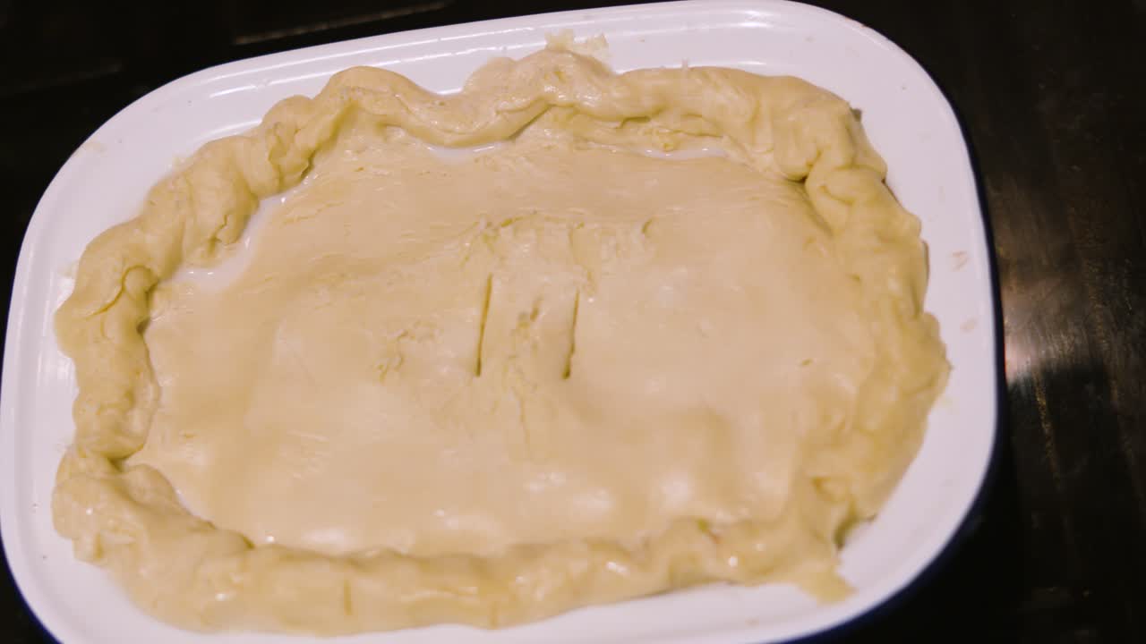 Freshly Made Chicken Vegetable Mushroom Pie with Shortcrust Pastry Ready to be Cooked in the Oven. Slow Moving Rotating Camera Top Down View.