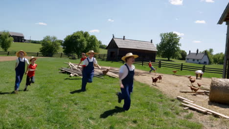 young boys working and playing on a farm with hay bales and chickens