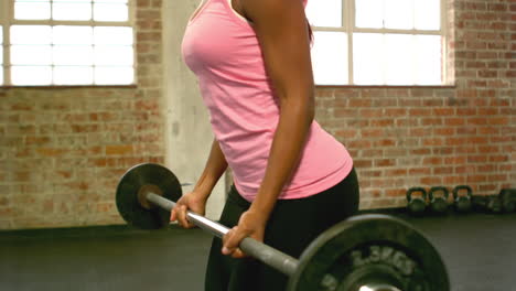 mujer en forma levantando pesas con barra