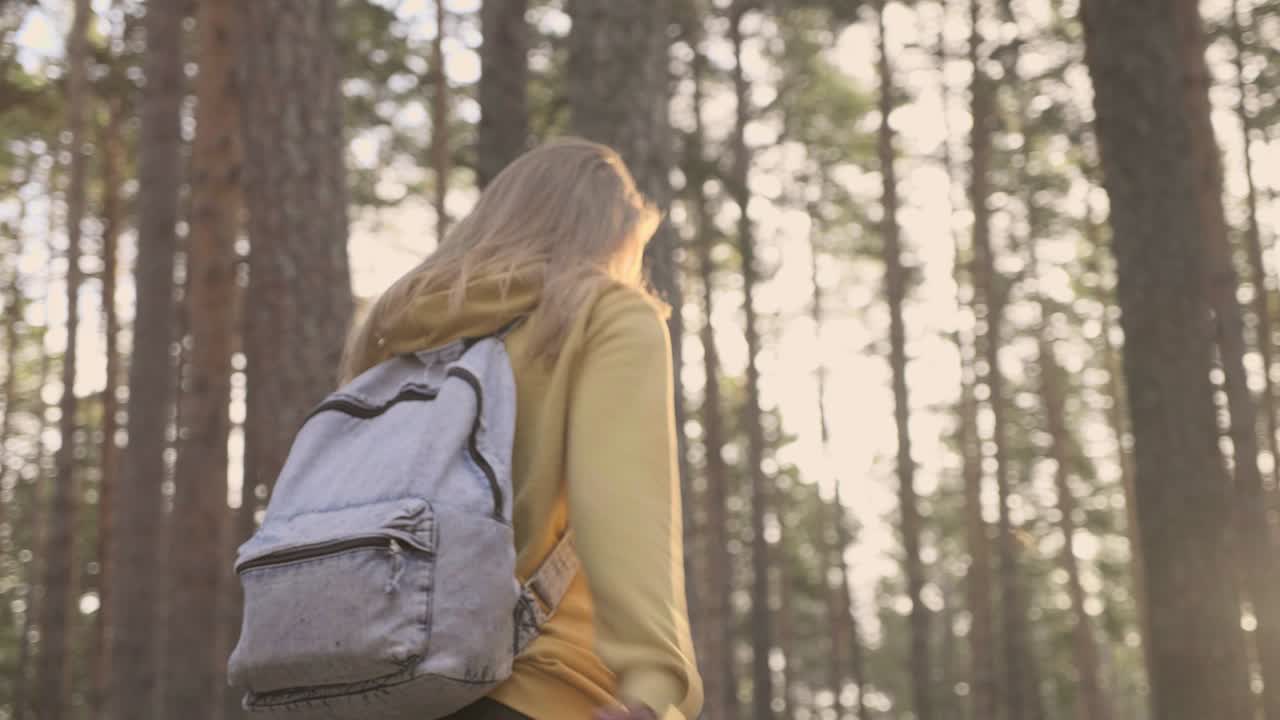 niña caminando en el bosque soleado en cámara lenta
