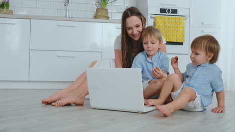 una joven madre progresista con dos hijos pequeños está hablando con su padre a través de la comunicación por video. la tecnología moderna es una familia joven.
