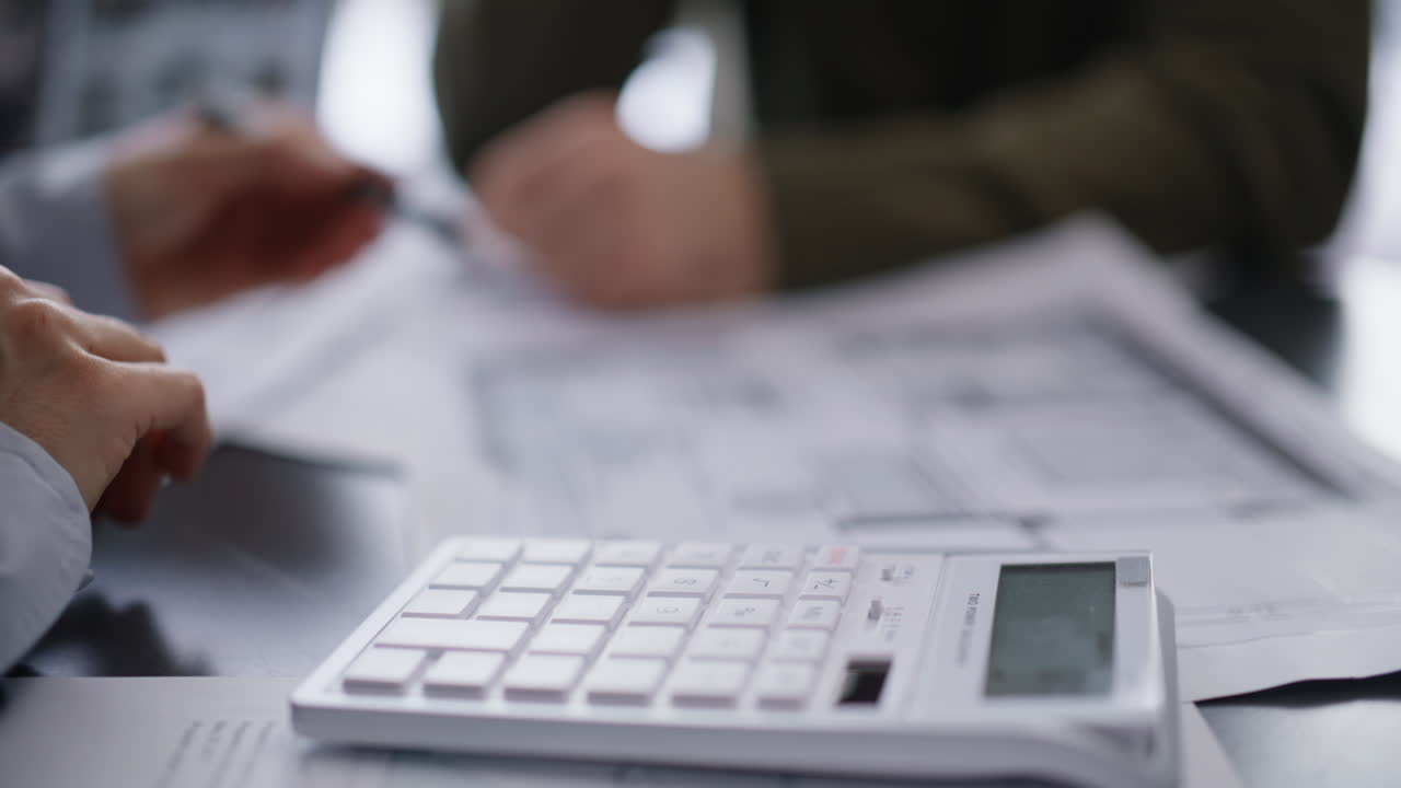 Ingegnere indica il piano con la mano calcolando il budget, primo piano dell’ufficio. Cliente architetto