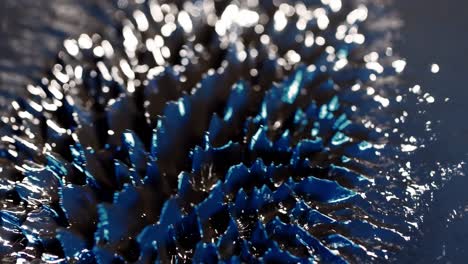 abstract macro shot of magnetic liquid ferrofluid moving motion with blue highlight