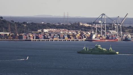 West-coast-Portugal,-green-floating-ship,-containers-in-background,-sunny-day-static-view
