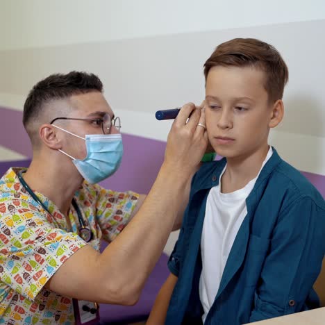 doctor examining boy ear