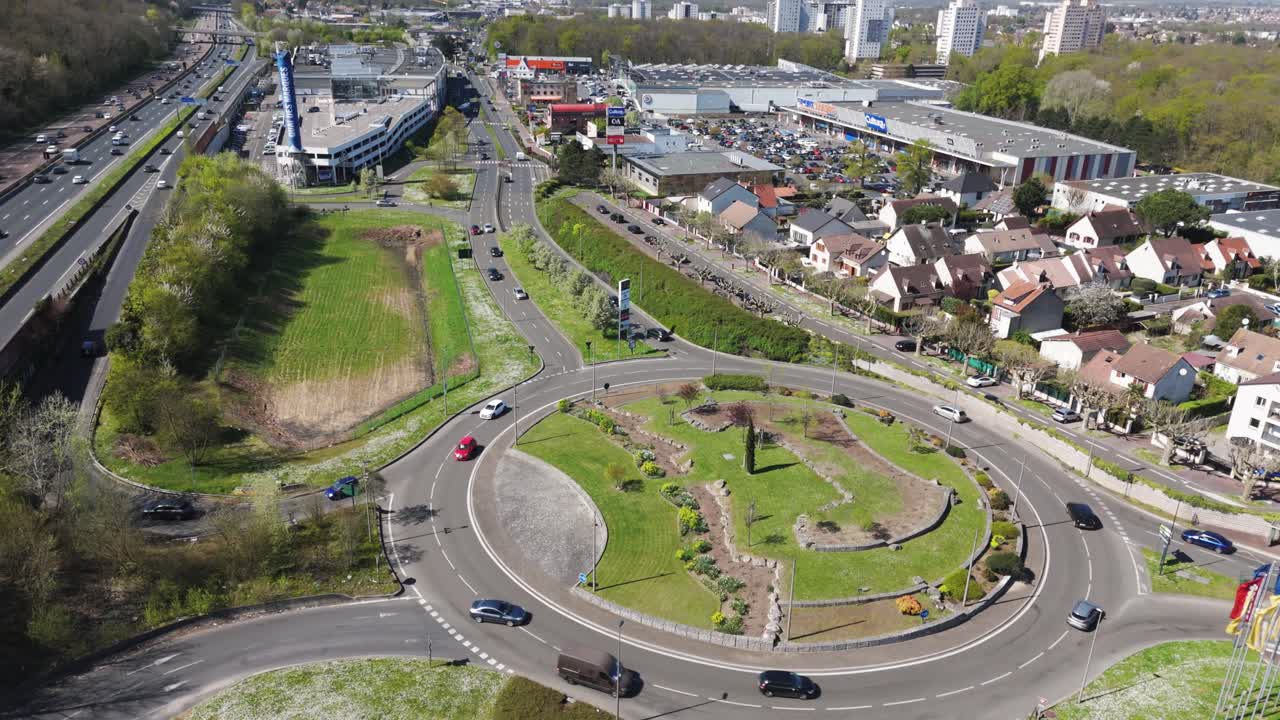 Drone shot over roundabout near shopping center in Franconville, with paris beltway and traffic - France
