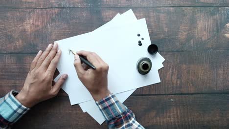 persona que escribe con una pluma pluma