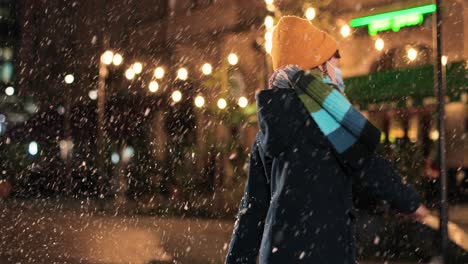 close-up view of caucasian cheerful little boy standing on street in christmas while playing and trying to catch snow