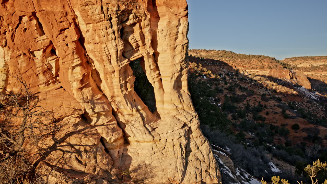 Aerial sunrise view of a beautiful sandstone arch standing tall near Kanab, Utah.