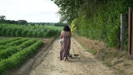 baby and mommy walking on a dirt road