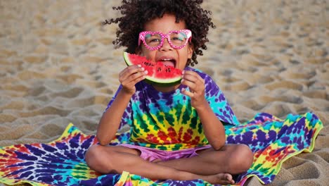 child eating watermelon on the beach