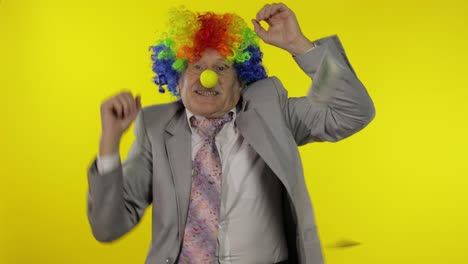 elderly clown businessman dancing, celebrate. money dollar cash falls from above